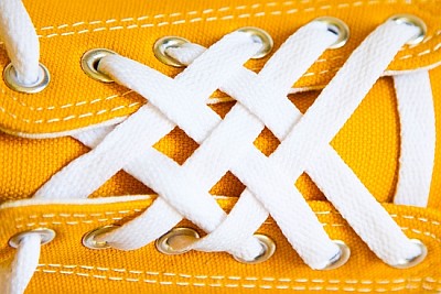 Laços brancos em tênis amarelos
