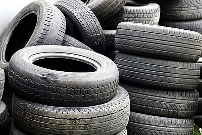 Old used car tires stacked in high piles