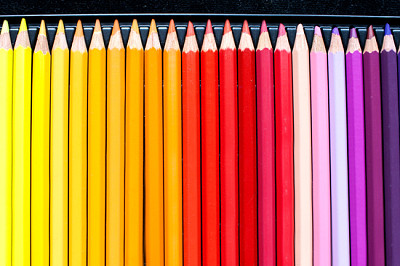 Línea de lápices de colores sobre fondo de terciopelo negro