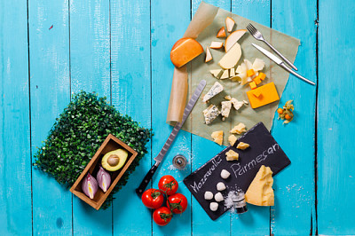 Verschiedene Käsesorten auf einem blauen Holztisch