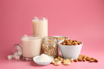Auswahl an leckerer veganer Milch auf farbigem Hintergrund