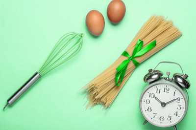 Culinary concept, cooking time. Alarm clock, pasta jigsaw puzzle