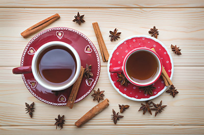פאזל של תה לשניים, תה חם בכוסות אדומות על שולחן עץ