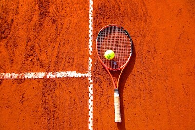 Bola de tênis na raquete de tênis no chão