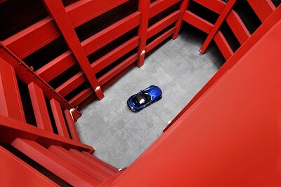 Coche azul en estacionamiento rojo