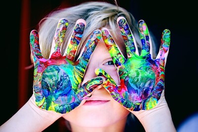 Uma criança com as mãos pintadas