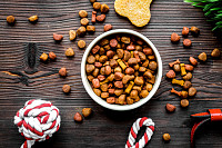 Dry dog food in bowl on wooden background top view
